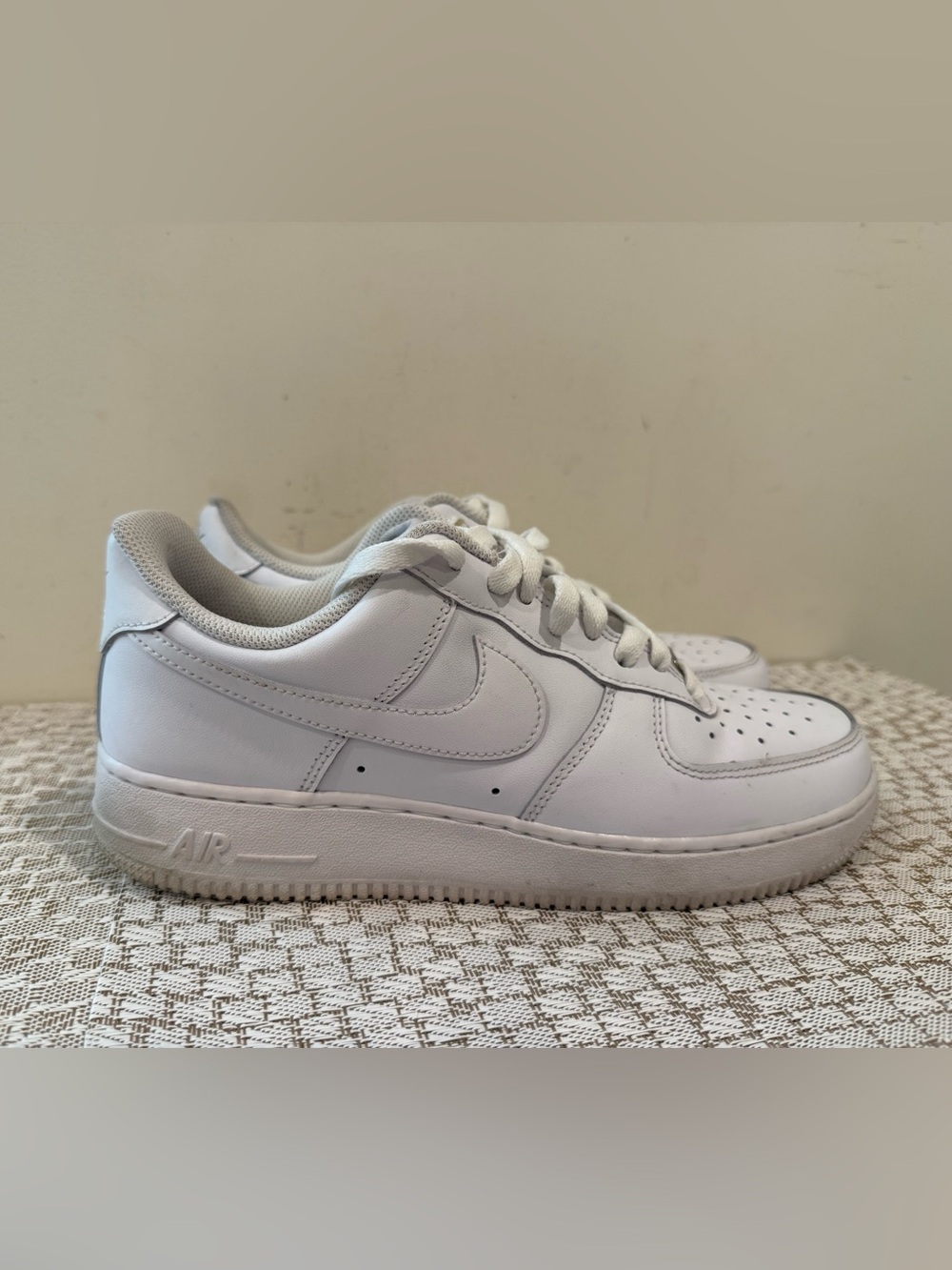 These are iconic Nike Air Force 1 sneakers in an all-white colorway.